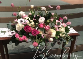 Whymsical pink ranunculus and anenome funeral urn spray